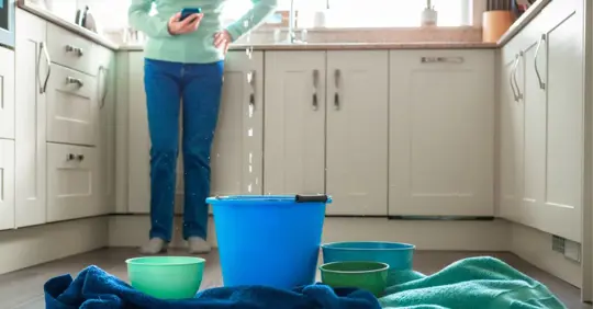 Worried home owner dealing with water leak in the kitchen